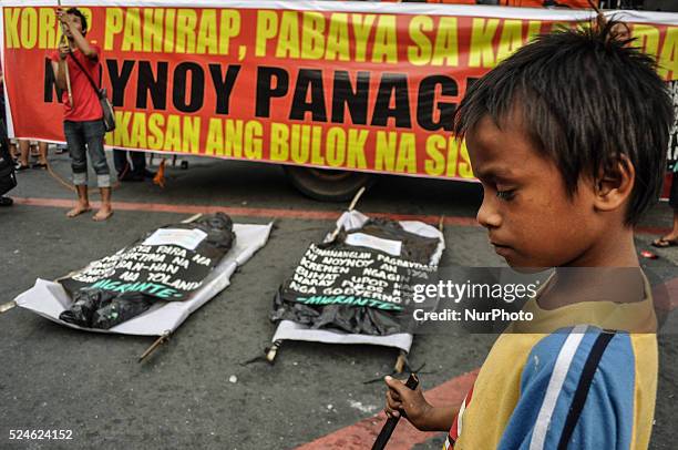 Child blinks as two mock-up body bags are laid down in front of the stage, depicting the body bags scattered at the typhoon devastated areas....