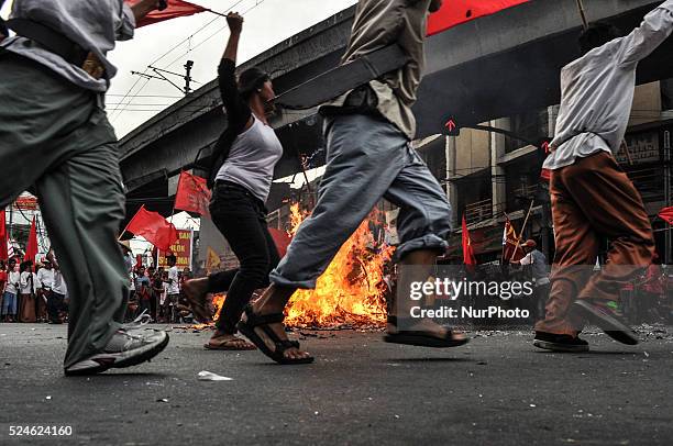 Protesters run around the burnt effigy shouting their protests at the historic Mendiola Bridge in San Miguel, Manila on Saturday, 30 November 2013....