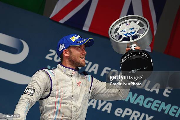 Virgin Racing driver Sam Bird of Great Britain looks at his trophy on the podium after winning Round 2 Formula E all-electric auto race in Putrajaya,...