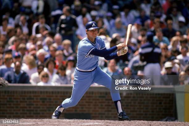 Dale Murphy of the Atlanta Braves follows through on his swing during a game against the Chicago Cubs in 1986 at Wrigley Field in Chicago, Illinois....