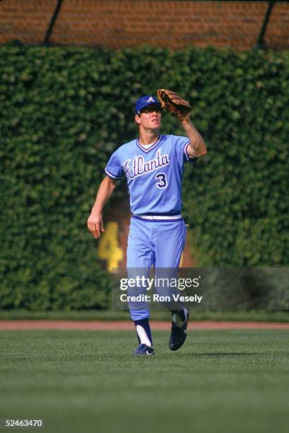 Dale Murphy of the Atlanta Braves runs in the outfield to make a catch during a game against the Chicago Cubs in 1986 at Wrigley Field in Chicago,...