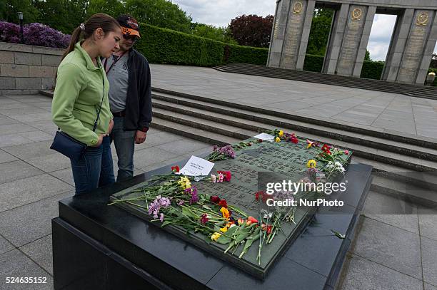 Tourists look at the Soviet War Memorial on on the Stra��e des 17. Juni in Berlin , Germany occupied a floral memorial stone . Throughout Europe, the...