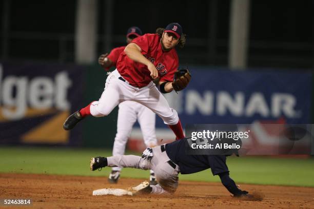 Mark Bellhorn of the Boston Red Sox leaps over a sliding Tony Womack of the New York Yankees as he watches his throw to first base during the...