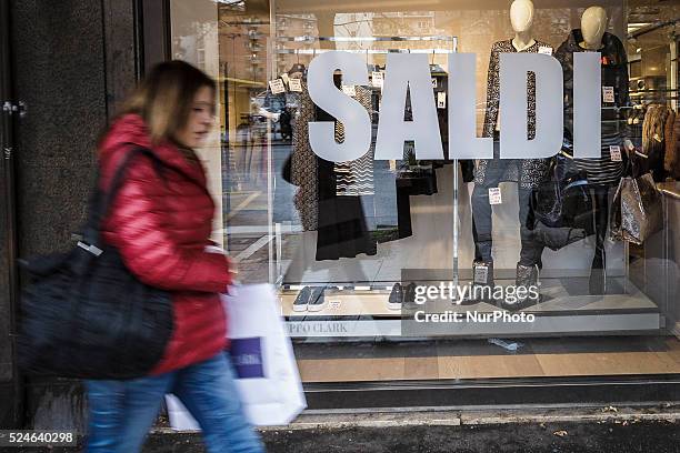Woman walks past a shop window offering generous discounts during the winter sales in downtown Rome, Italy, on January 5, 2016. The first day of...