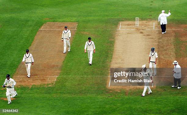 Umpire David Shepherd calls for the covers as the players leave the field as rain stops play during day five of the 2nd Test between New Zealand and...