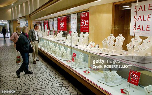 Shoppers look at the display window of an Angus and Coote jewellery store in Sydney, 22 March 2005, as the Angus and Coote group announces a 7.8...