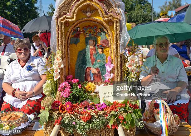 Representatives from Parish Godowa, dressed in traditional folk costumes, seat near their Parish wreaths and loaves during the Holy Mass at the 2015...