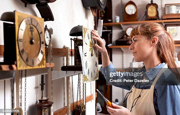 apprentice clock repairer in workshop - antique clocks stock pictures, royalty-free photos & images