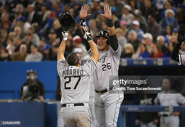 Dioner Navarro of the Chicago White Sox is congratulated by Avisail Garcia after hitting a two-run home run in the seventh inning during MLB game...