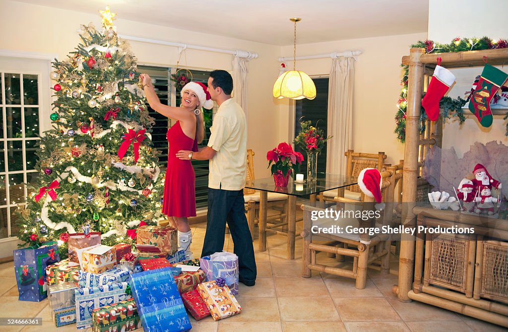 Affectionate couple decorate an Christmas tree