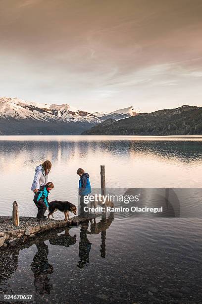 family with dog on a lake - bariloche argentina stock pictures, royalty-free photos & images