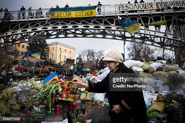 People leave flowers and mourn at a makeshift memorial in homage to anti-government protesters killed in the past weeks' clashes with riot police on...