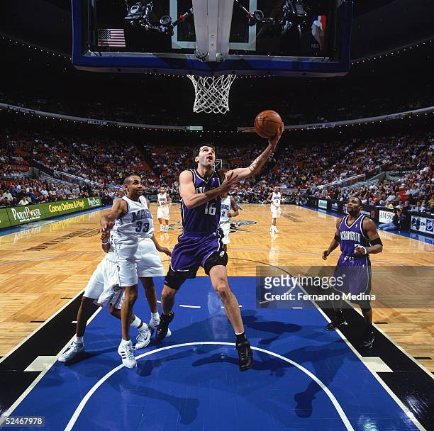 Peja Stojakovic of the Sacramento Kings goes up for a layup past Grant Hill of the Orlando Magic during a game at TD Waterhouse Centre on March 2,...