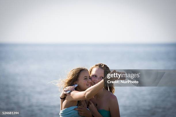 Teenage girls are seen taking selfies at the beach during a hot weather spel on 1st July 2015 in The Hauge, Netherlands.