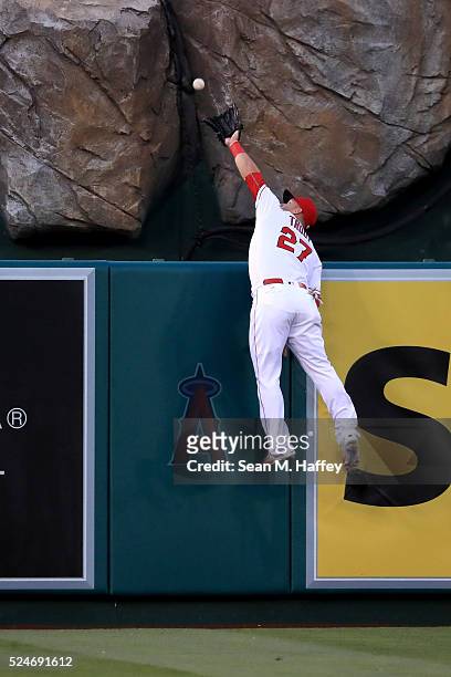 Mike Trout of the Los Angeles Angels of Anaheim leaps unsuccessfully to catch this home run by Mike Moustakas of the Kansas City Royals during the...