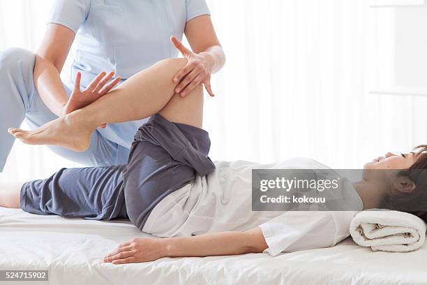 women receiving the foot massage in the clinic - physiotherapy asian stock pictures, royalty-free photos & images