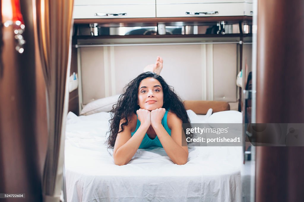 Young woman lying on bed in camper