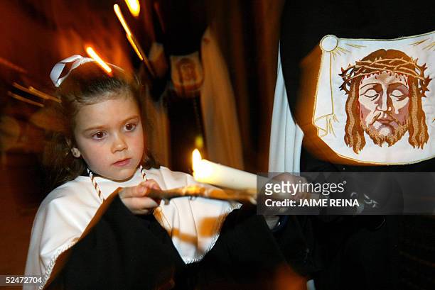 Girl cleans the candle's wax of a penitent during a "Santo Cristo de la Santa Cruz" procession in Palma de Mallorca, late 23 March 2005. The Catholic...