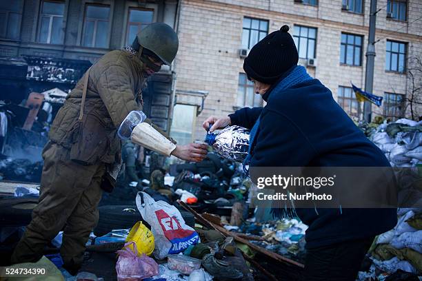Woman offers hot tea at a barricades set by Ukrainian Pro-European opposition activists at Kiev's Independence Square on December 31, 2013. Ukraine's...