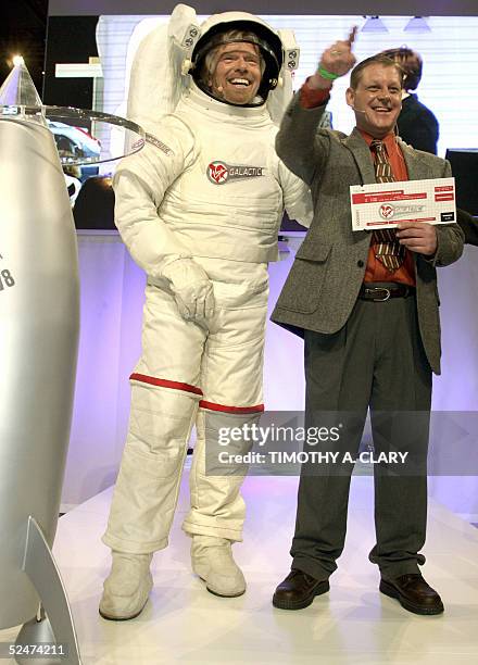 Virgin Atlantic Founder Richard Branson wearing a spacesuit poses with Doug Ramsburg , the winner of his Virgin Galatic Sub-Orbital flight , during a...