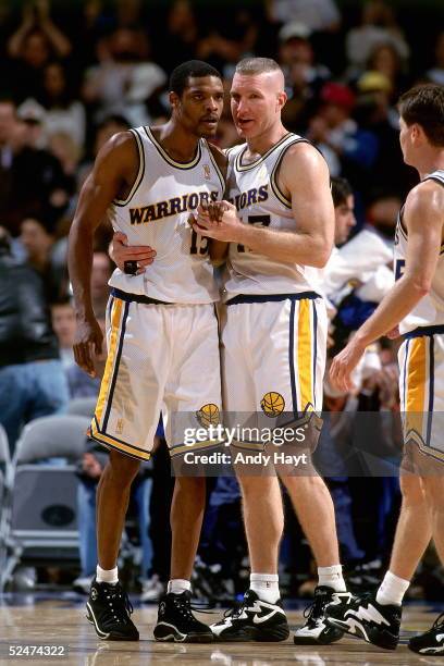 Latrell Sprewell#15 and Chris Mullin of the Golden State Warriors converse with one another during a break in the game against the Philadelphia 76ers...