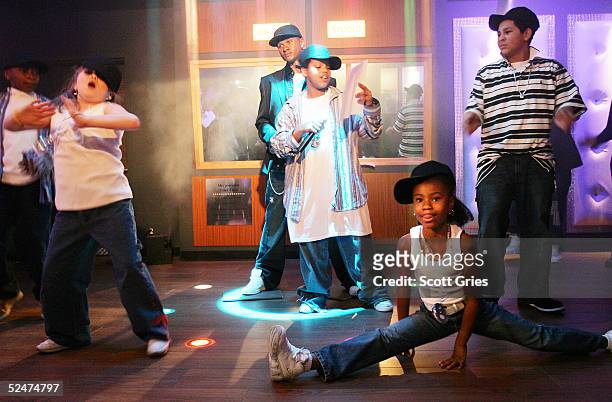 Children sing and dance along side the new wax figure of R & B singer Usher during a competition to launch the Usher Interactive Experience at Madame...