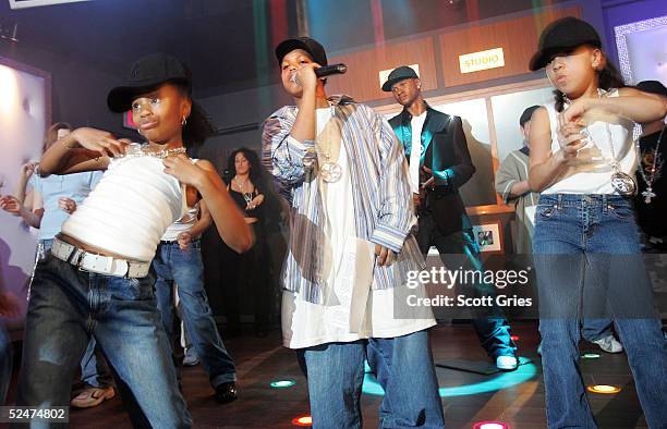 Children sing and dance along side the new wax figure of R & B singer Usher during a competition to launch the Usher Interactive Experience at Madame...