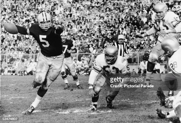 American professional football player Paul Hornung , halfback for the Green Bay Packers, carries the ball through a hole in the defense during a...
