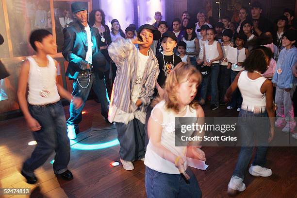 Children sing and dance along side the new wax figure of R & B singer Usher during a competition to launch the Usher Interactive Experience at Madame...