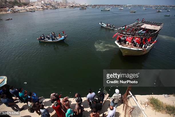 Palestinian woman holds a Turkish flag as activists ride a boat during a rally ahead of the 4th anniversary of the Mavi Marmara Gaza flotilla...