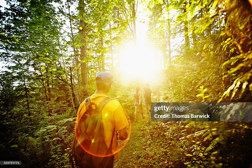 Group of friends walking down trail through woods