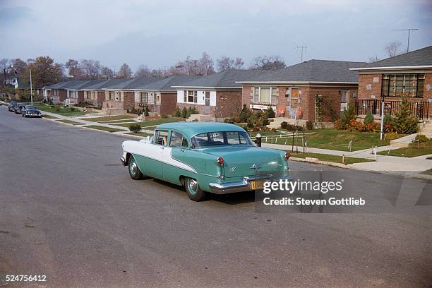 Vintage Chevrolet Driving Down Residential Street