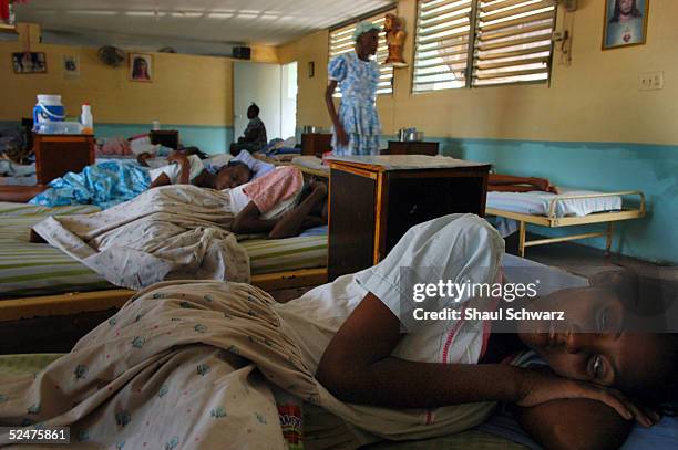 Woman infected with HIV lies in her bed at the Sisters Missionary of Charity Hospital March 22, 2005 in Port-au-Prince, Haiti. The hospital is one of...