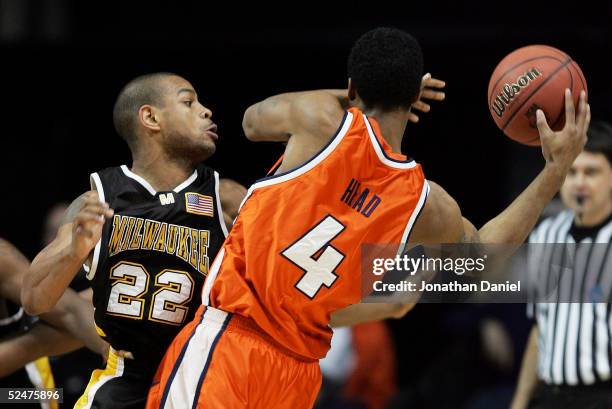 Ed McCants of the Wisconsin-Milwaukee Panthers reaches in to try to steal the ball from Luther Head Illinois Fighting Illini in game one of the...