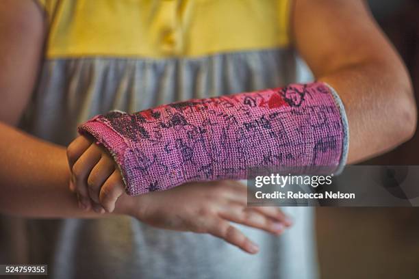 midsection of girl showing her signed arm cast - orthopedic cast stock pictures, royalty-free photos & images