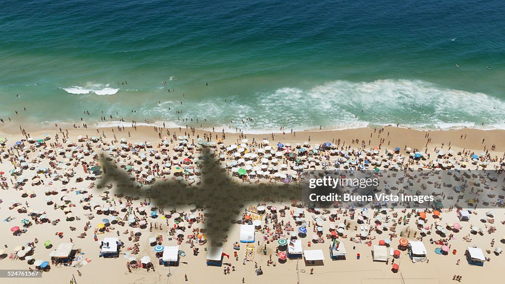 Airplane's shadow over a crowded beach