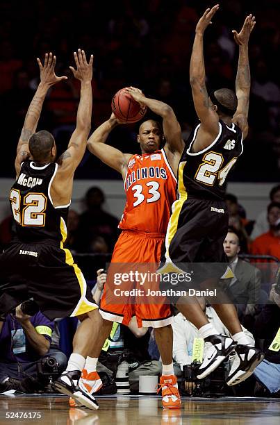 Richard McBride of the Illinois Fighting Illini looks to pass between the defense of Ed McCants and Boo Davis of the Wisconsin-Milwaukee Panthers in...