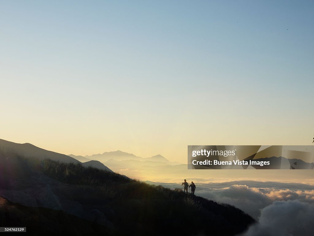 Couple on a mountain slope over fog