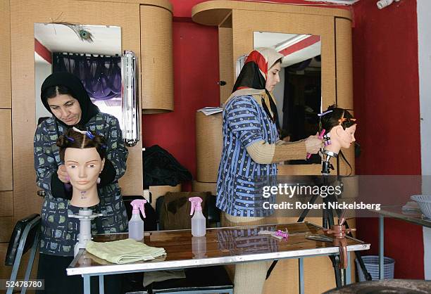 Afghan women practice on mannequin heads at Debbie Rodriguez's Oasis Beauty School February 13, 2005 in Kabul, Afghanistan. Rodriguez operates the...