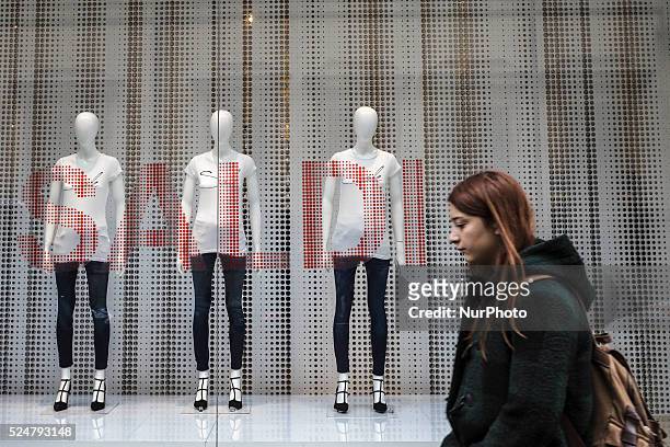 Woman walks past a shop window offering discounts during the winter sales in downtown Rome, Italy, on January 5, 2016. The first day of winter sales...