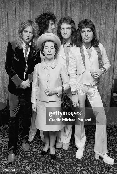 British rock band Queen posing with actress and Queen Elizabeth II look-alike, Jeannette Charles, September 1974. The group are drummer Roger Taylor,...