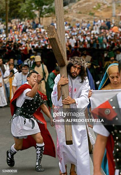 Un hombre representando a Jesus, carga su cruz, durante la escenificacion del Via Crusis el Viernes Santo, en el pueblo de Cuajimalpa, en la zona...