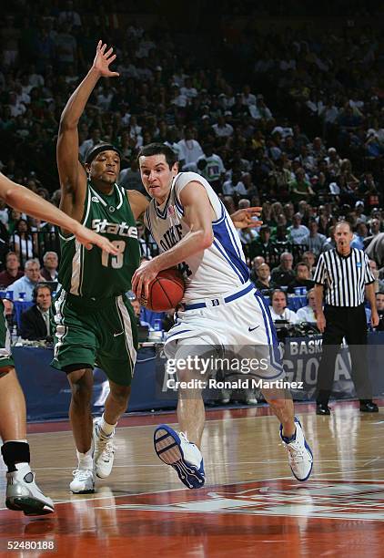 Redick of the Duke Blue Devils drives with the ball past Maurice Ager of the Michigan State Spartans during the 2005 NCAA division 1 men's basketball...