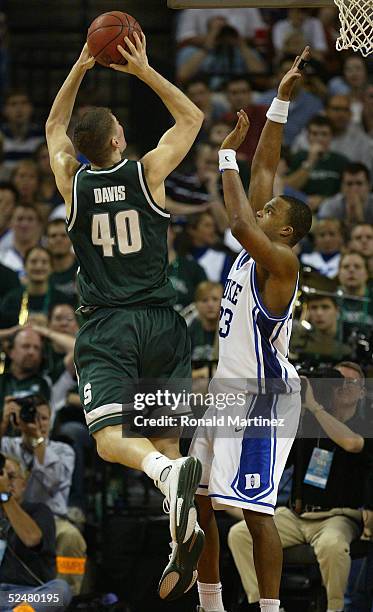 Shelden Williams of the Duke Blue Devils attempts to stop the shot by Paul Davis of the Michigan State Spartans during the 2005 NCAA division 1 men's...