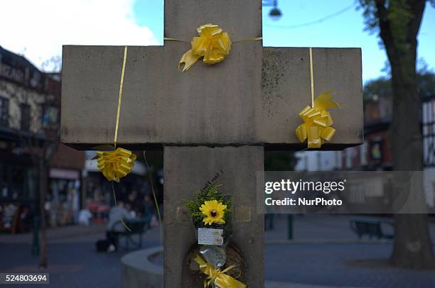 Member of the community laying a floral tribute, for Alan Henning, in Eccles town centre, in Salford, England