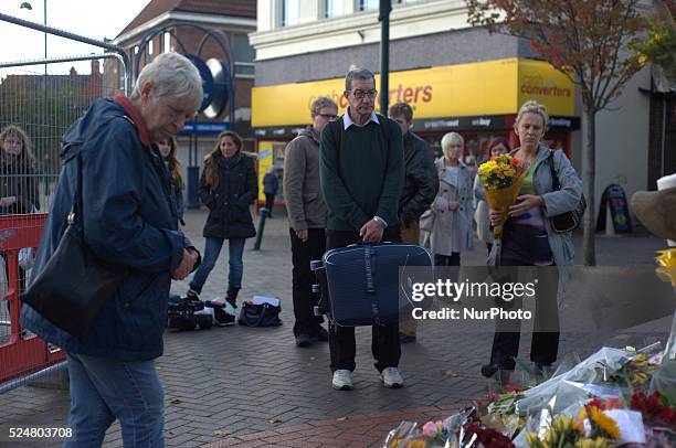 Member of the community laying a floral tribute, for Alan Henning, in Eccles town centre, in Salford, England