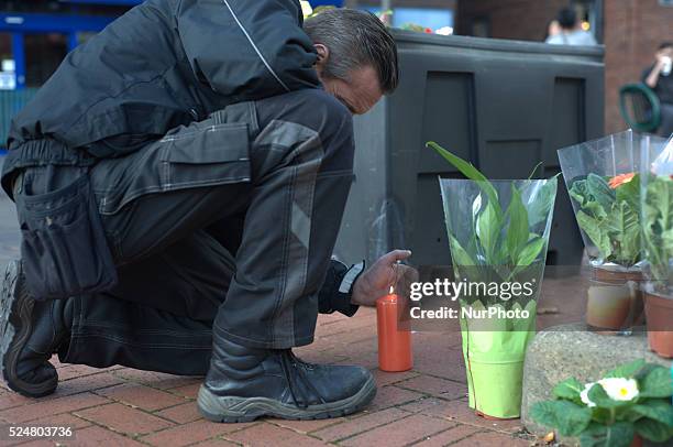 Member of the community laying a floral tribute, for Alan Henning, in Eccles town centre, in Salford, England