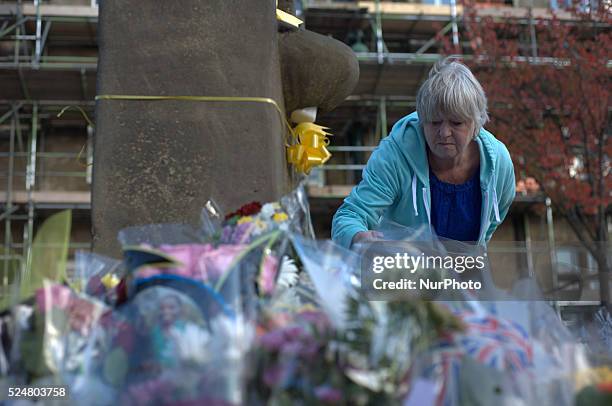 Member of the community laying a floral tribute, for Alan Henning, in Eccles town centre, in Salford, England