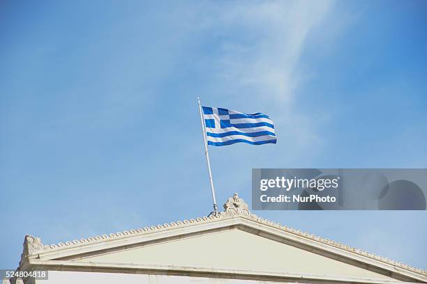 Waving Greek flag on top of the Parliament, in Athens, Greece, on March 17, 2015.