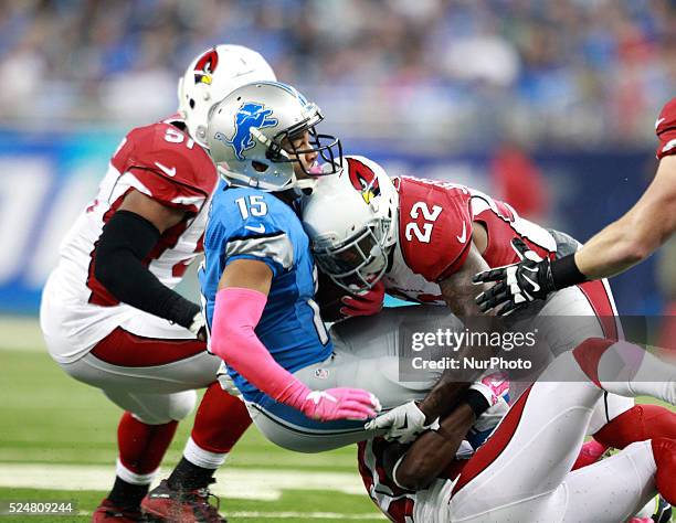 Detroit Lions wide receiver Golden Tate is tackled by Arizona Cardinals safety Tony Jefferson and cornerback Jerraud Powers during the first half of...